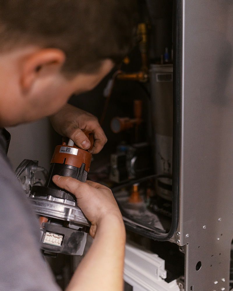 Monteur bei der Arbeit am geöffneten Heizgerät